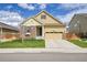 Inviting yellow two-story home with a stone facade and a two-car garage at 16076 Columbine Pl, Thornton, CO 80602