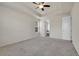 Large bedroom with ensuite bathroom, neutral carpet, ceiling fan, and bright natural light at 16076 Columbine Pl, Thornton, CO 80602