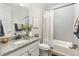 Well-lit bathroom featuring a granite vanity, framed plant art, and coordinated shower curtain at 21893 E Tufts Cir, Aurora, CO 80015