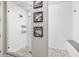 Modern bathroom featuring walk-in shower with river rock floor and decorative wall art at 21893 E Tufts Cir, Aurora, CO 80015