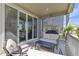 Comfortable outdoor seating on the covered patio with view of the backyard and sliding glass doors at 21893 E Tufts Cir, Aurora, CO 80015