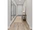 Inviting hallway with hardwood floors, stylish decor, and a series of decorative mirrors at 21893 E Tufts Cir, Aurora, CO 80015