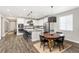 Bright, eat-in kitchen with white cabinets, stainless steel appliances, and dark wood accents at 21893 E Tufts Cir, Aurora, CO 80015