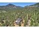 House nestled in a wooded mountain setting at 322 Greystone Rd, Evergreen, CO 80439