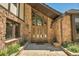 Stone entryway with a wood door and glass accents, flanked by landscaping at 322 Greystone Rd, Evergreen, CO 80439