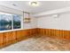Unfurnished basement room with wood paneling, tile flooring, and a bright window at 1836 S Kendall Ct, Lakewood, CO 80232