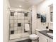 Bathroom showcasing a tiled shower with glass doors, white cabinets, and granite countertop at 1836 S Kendall Ct, Lakewood, CO 80232