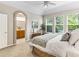Inviting bedroom featuring large windows, a ceiling fan, and an ensuite bathroom for added convenience at 1836 S Kendall Ct, Lakewood, CO 80232