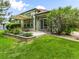 Home's exterior with a concrete patio, striped awning, beautiful landscaping, a sliding glass door, and complementary green trim at 1836 S Kendall Ct, Lakewood, CO 80232