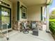 Covered front porch features stone accents, seating and a view of the surrounding neighborhood at 1836 S Kendall Ct, Lakewood, CO 80232