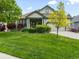 Beautiful single-Gathering home featuring a well-maintained lawn, lovely landscaping, and attached garage at 1836 S Kendall Ct, Lakewood, CO 80232