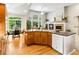Well-lit kitchen featuring wooden floors, ample counter space, and seamless connection to the living area with backyard views at 1836 S Kendall Ct, Lakewood, CO 80232