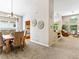 Open-concept dining and living space featuring neutral decor and seamless flow to the living room at 1836 S Kendall Ct, Lakewood, CO 80232