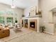 Inviting living room with large windows, a cozy fireplace, and comfortable seating arrangement with vaulted ceiling at 1836 S Kendall Ct, Lakewood, CO 80232