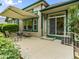 Concrete patio with striped awning, table with chairs, sliding glass door, and complementary green trim at 1836 S Kendall Ct, Lakewood, CO 80232
