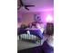 Cozy bedroom featuring a ceiling fan and warm purple lighting at 12714 Leyden St # C, Thornton, CO 80602