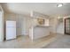 Spacious basement area with tile floors, featuring a bar, refrigerator, and stairs to the upper level at 7036 Orion Ln, Arvada, CO 80007