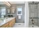 Well-lit bathroom showcasing a shower-tub combo with a tile surround and a wood vanity at 7036 Orion Ln, Arvada, CO 80007