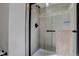 Modern shower with glass enclosure and neutral tiling complemented by dark hardware at 7036 Orion Ln, Arvada, CO 80007