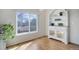 Bright and airy dining area featuring hardwood floors, a large window, and a decorative hutch at 7036 Orion Ln, Arvada, CO 80007