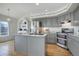 Spacious kitchen featuring a center island, gray cabinets, marble countertops, and modern appliances at 7036 Orion Ln, Arvada, CO 80007