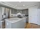 Stylish kitchen boasting gray cabinetry, a marble countertop island, and stainless steel appliances at 7036 Orion Ln, Arvada, CO 80007