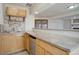 Lower level wet bar featuring wood cabinetry, stainless steel dishwasher and tile backsplash at 7036 Orion Ln, Arvada, CO 80007