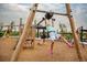 Kid dangles from playground equipment on a playground covered in engineered wood fiber at 27554 E Byers Ave, Aurora, CO 80018