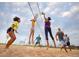 Group of people play volleyball on a sand court on a sunny day with cloudy skies at 27554 E Byers Ave, Aurora, CO 80018