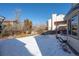 Backyard featuring a well-maintained lawn, deck with seating, and winter trees at 10407 Strasburg Way, Parker, CO 80134