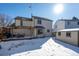 Backyard with a wooden deck, pergola, and a snow-covered lawn at 10407 Strasburg Way, Parker, CO 80134