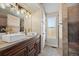 Updated bathroom featuring double sinks, modern lighting, and a tiled shower at 10407 Strasburg Way, Parker, CO 80134