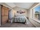 Bright bedroom featuring a large window, barn door, and light color palette at 10407 Strasburg Way, Parker, CO 80134