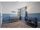 Bright blue Bedroom featuring a crib, window with blinds, and modern decor at 10407 Strasburg Way, Parker, CO 80134