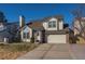Traditional two-story home with a brick and siding facade, a two-car garage, and a well-kept front lawn at 10407 Strasburg Way, Parker, CO 80134