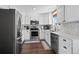 Modern kitchen with stainless steel appliances, white cabinets, and stylish backsplash at 10407 Strasburg Way, Parker, CO 80134