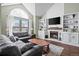 Cozy living room with fireplace, built-in shelves, and natural light from a large window at 10407 Strasburg Way, Parker, CO 80134