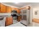 Well-lit kitchen featuring stainless steel appliances, tiled floors and oak cabinets at 3144 S Wheeling Way # 106, Aurora, CO 80014