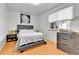 Bedroom with a bed, wood floors, neutral walls, and a large window at 16608 E 13Th Ave, Aurora, CO 80011