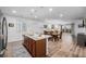 Bright kitchen flows into dining and living areas, featuring pendant lighting, a large island, and modern appliances at 27957 E 9Th Dr, Aurora, CO 80018