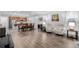 Open-concept living room features hardwood floors, modern lighting, and comfortable seating, flowing into dining and kitchen areas at 27957 E 9Th Dr, Aurora, CO 80018