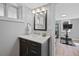 Updated bathroom features a modern vanity, stylish mirror, and access to an adjacent room with exercise equipment at 772 Garfield St, Denver, CO 80206