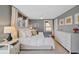 Bright bedroom with a ceiling fan, neutral walls, a bed with decorative pillows, and a white dresser at 772 Garfield St, Denver, CO 80206