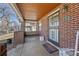 A brick porch with a wood ceiling, decorative security door, and swing in the background at 772 Garfield St, Denver, CO 80206