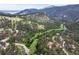 Breathtaking aerial view of mountain property surrounded by lush greenery and a winding road at 207 Kelly E Rd, Boulder, CO 80302
