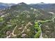 Aerial view of the neighborhood with winding roads, mature trees, and mountain views at 207 Kelly E Rd, Boulder, CO 80302