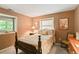Cozy bedroom with a patterned quilt, decorative pillows, and views from two windows at 207 Kelly E Rd, Boulder, CO 80302