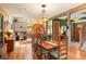 Open-concept dining room featuring hardwood floors, rustic wood beam and chandelier, and a connected living area at 207 Kelly E Rd, Boulder, CO 80302