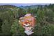 Stunning mountain home featuring multi-tiered decks and an elegant stone chimney surrounded by lush evergreen trees at 207 Kelly E Rd, Boulder, CO 80302