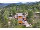 Aerial view of mountain home with a deck, stone chimney, and surrounding trees at 207 Kelly E Rd, Boulder, CO 80302